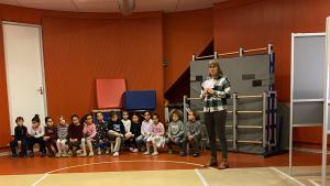 Schoolkinderen in een stembureau met juf